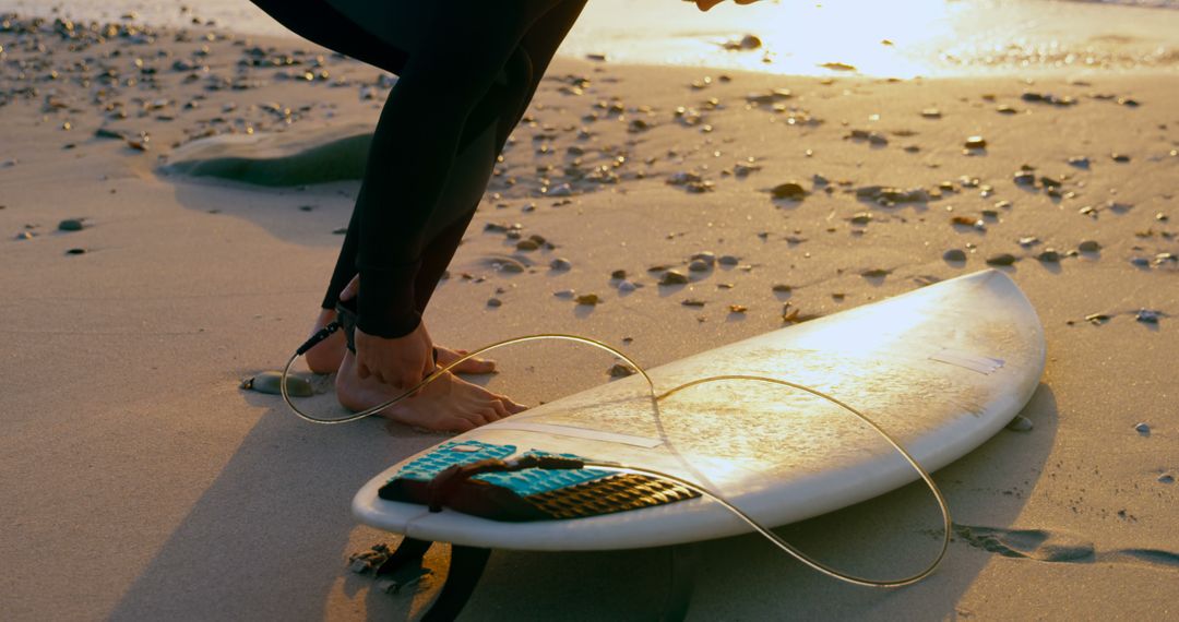 Surfer Preparing Surfboard on Beach at Sunset - Free Images, Stock Photos and Pictures on Pikwizard.com