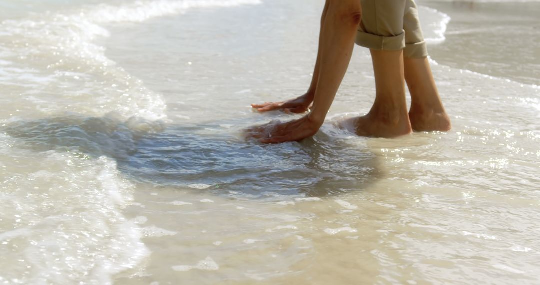 Senior Woman Enjoying Beach Waves During Leisure Stroll