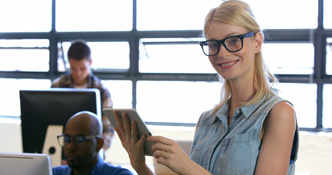 Smiling Woman with Tablet in Office Setting - Free Images, Stock Photos and Pictures on Pikwizard.com