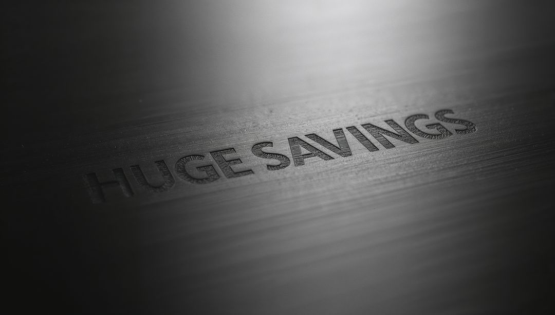Embossed HUGE SAVINGS on Brushed Metal Panel Showing Dramatic Highlight and Macro Grain