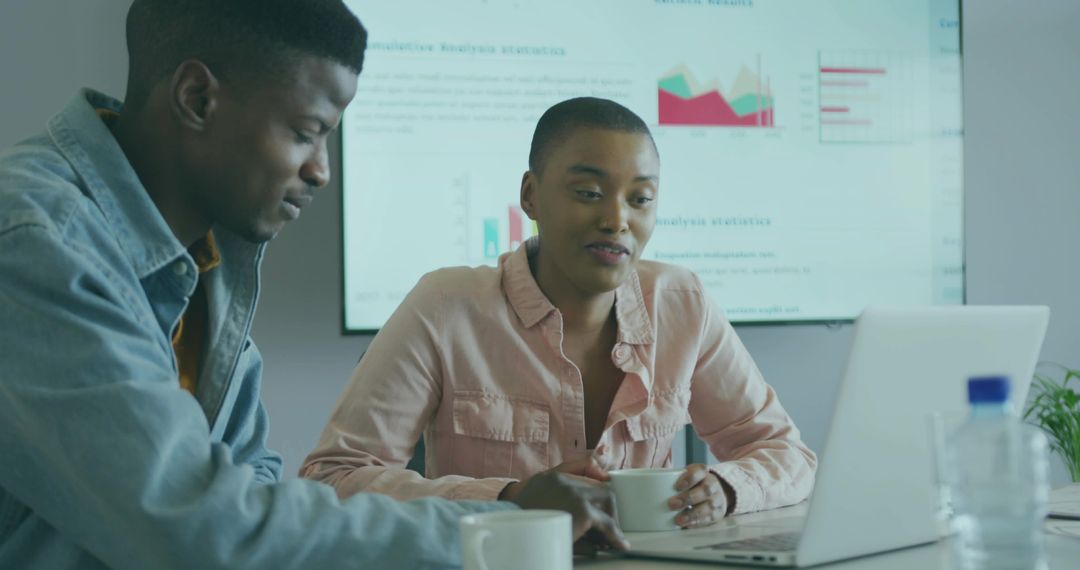 Professional Team Analyzing Data with Charts and Laptop