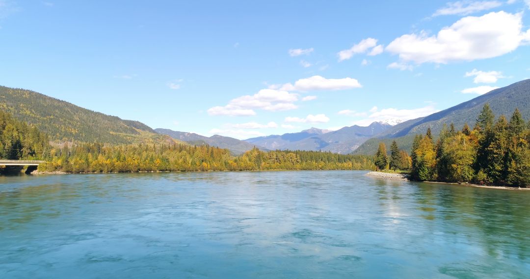 Serene River Flowing Amidst Forested Mountains on a Clear Day - Free Images, Stock Photos and Pictures on Pikwizard.com