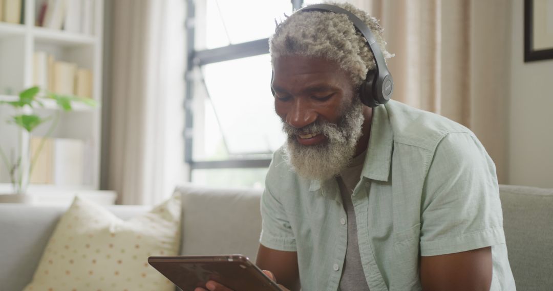 Elderly African American Man Enjoying Music on Tablet at Home - Free Images, Stock Photos and Pictures on Pikwizard.com