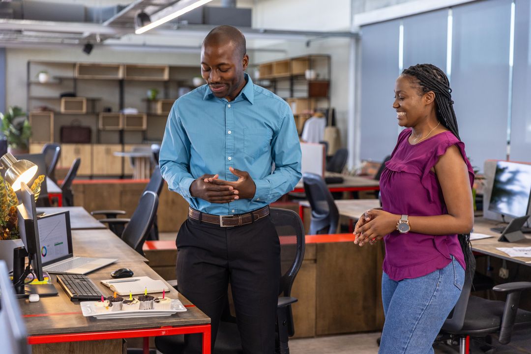 Coworkers Reviewing Tech Prototype in Open-Plan Office