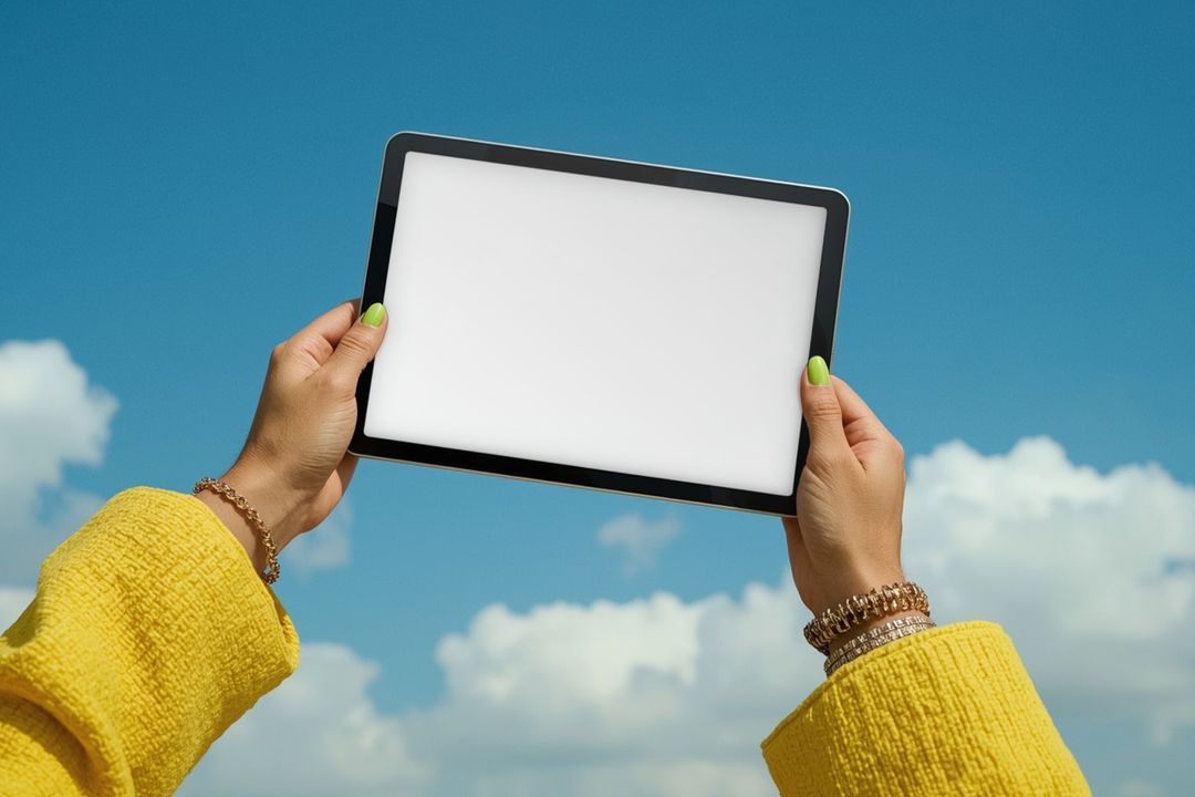 Hands Holding Digital Tablet Against Blue Sky
