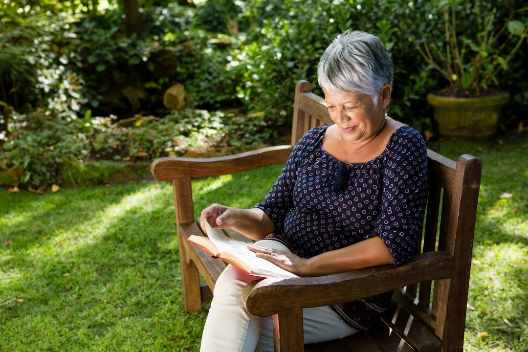 Senior Woman Reading Book on Garden Bench - Free Images, Stock Photos and Pictures on Pikwizard.com