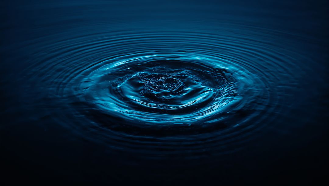 Rippling waves: impact of water droplet on blue surface emphasizing tranquility