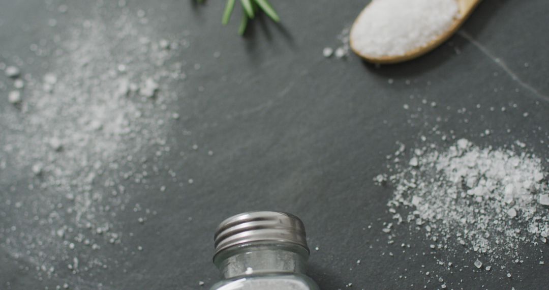 Salt Shaker and Granules on Dark Stone Countertop