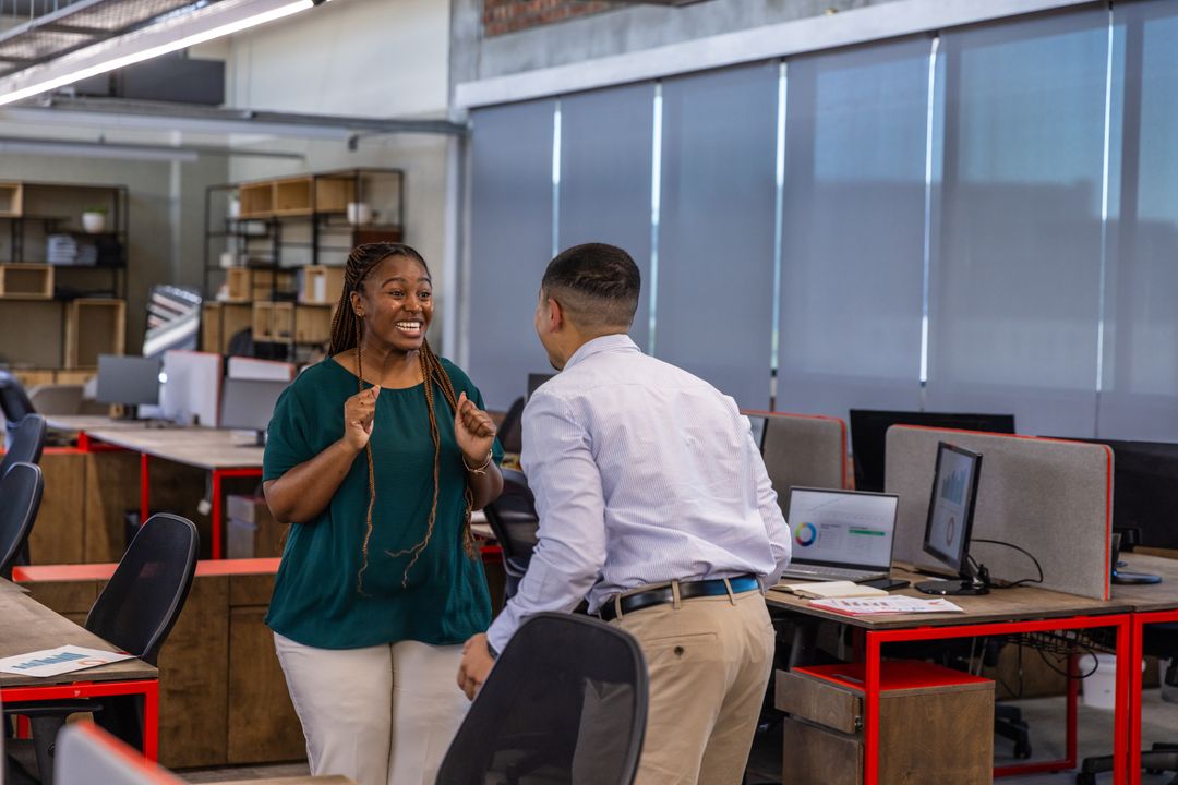 Diverse Coworkers Celebrating Success in Open Office