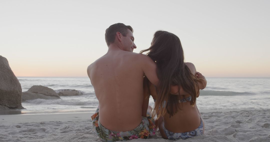 Romantic Couple Sitting on Beach at Sunset - Free Images, Stock Photos and Pictures on Pikwizard.com