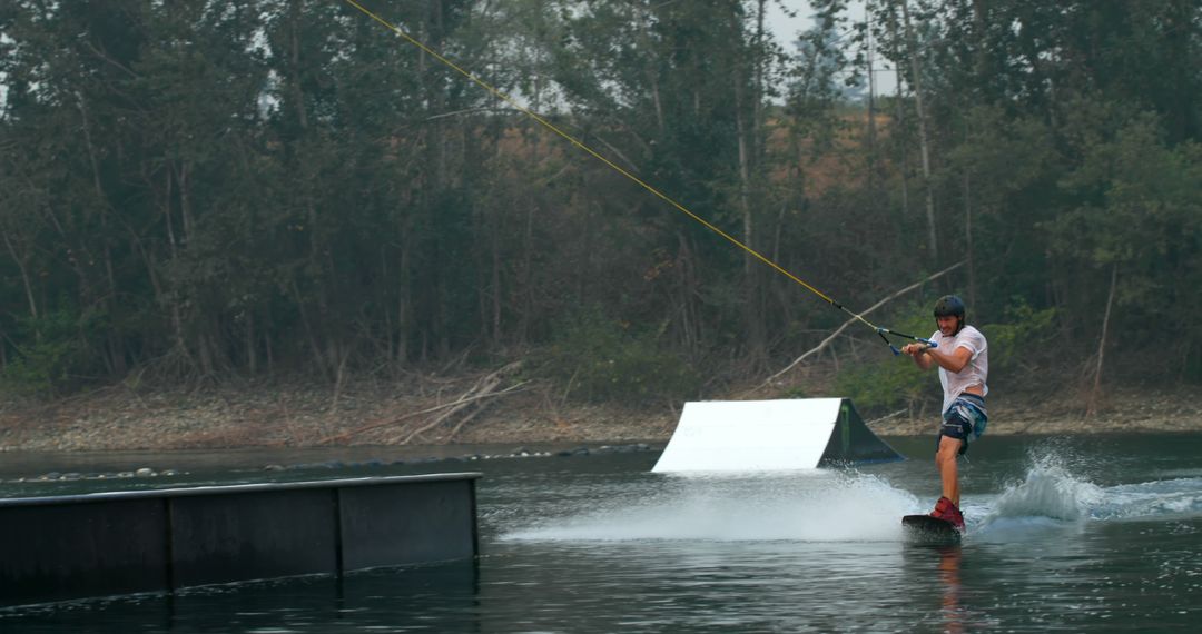 Man Wakeboarding in Lake with Forest Background - Free Images, Stock Photos and Pictures on Pikwizard.com