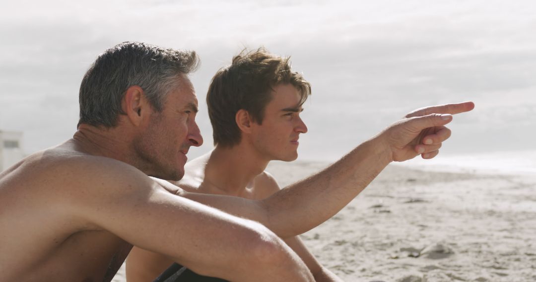 Man with Young Man by the Beach Pointing in Distance - Free Images, Stock Photos and Pictures on Pikwizard.com