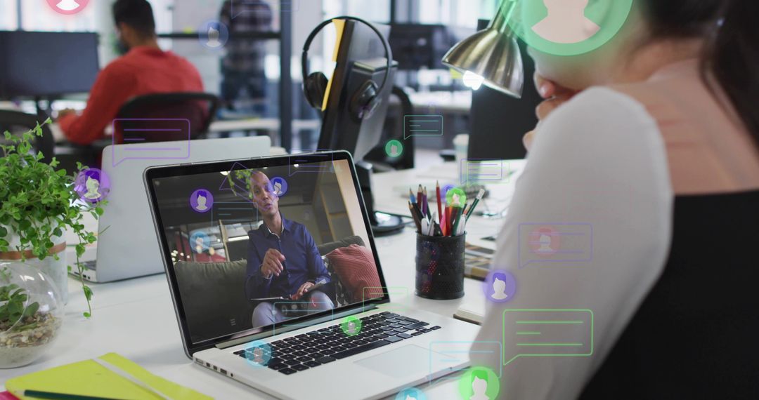 Remote presenter leading virtual meeting on laptop while coworker viewing in modern office