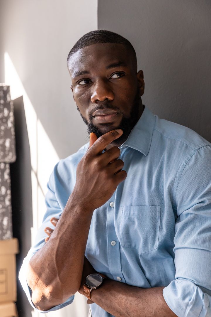 Contemplative Professional Man Holding Chin in Office Environment