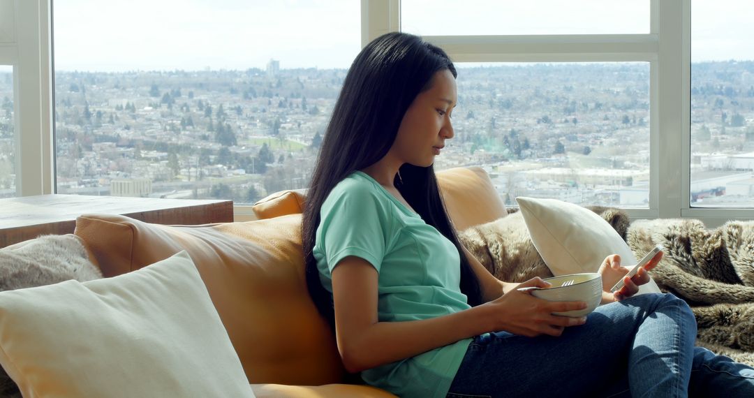 Woman Relaxing on Couch with Bowl in Hand - Free Images, Stock Photos and Pictures on Pikwizard.com