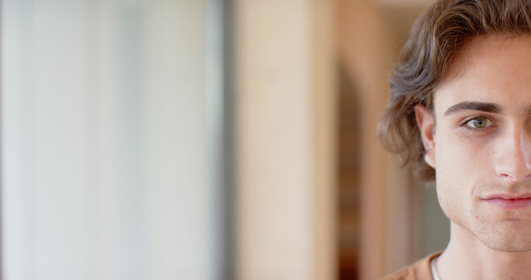 Close-Up Portrait of Young Man with Half Visible Face Near Frosted Window