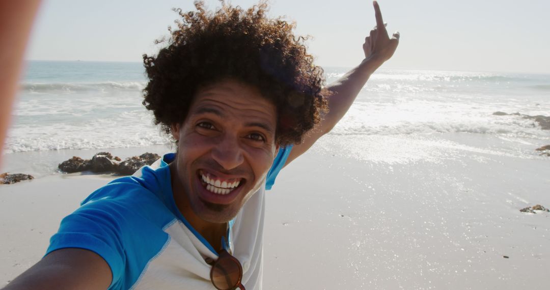 Excited Man Taking Selfie on Beach Pointing at Sky - Free Images, Stock Photos and Pictures on Pikwizard.com