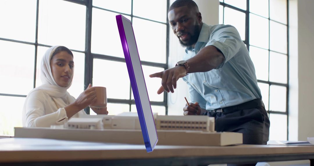 Architects Collaborating Over Digital Model in Modern Studio