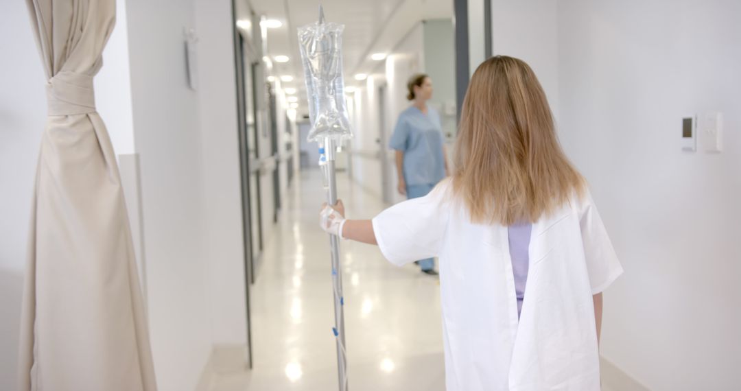 Patient Walking in Hospital Corridor with IV Pole - Free Images, Stock Photos and Pictures on Pikwizard.com