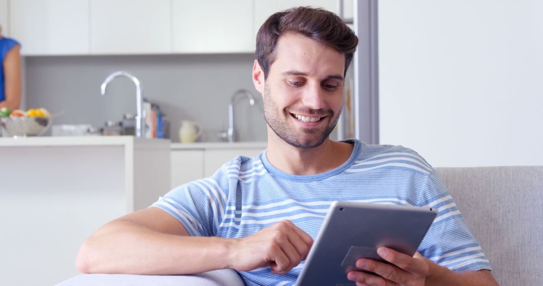 Smiling Man Using Digital Tablet in Modern Home - Free Images, Stock Photos and Pictures on Pikwizard.com