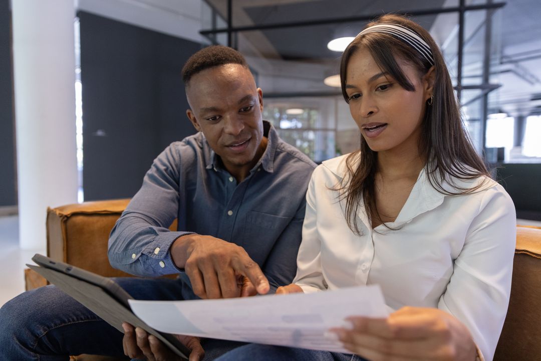 Coworkers Collaborating in Modern Office Setting with Technology
