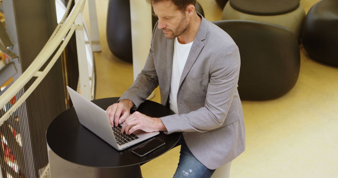 Businessman Working on Laptop in Modern Office Space - Free Images, Stock Photos and Pictures on Pikwizard.com