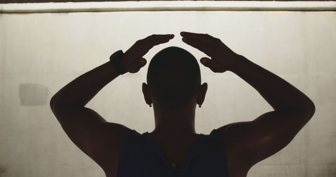 A biracial man in sportswear rests with hands on his head, viewed from behind. - Free Images, Stock Photos and Pictures on Pikwizard.com