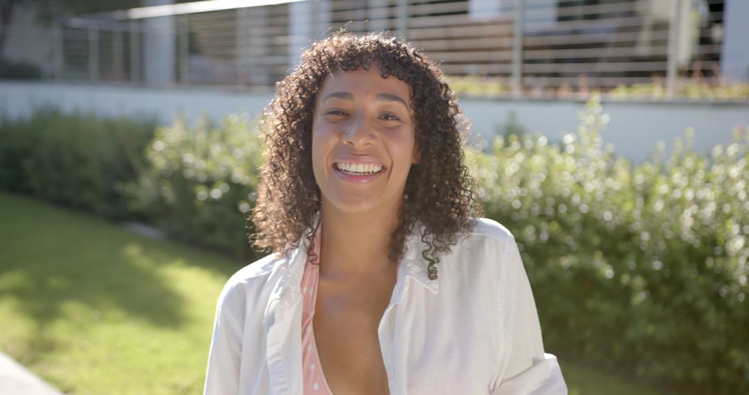 Smiling Woman Relaxing in Sunny Backyard, Enjoying Leisure