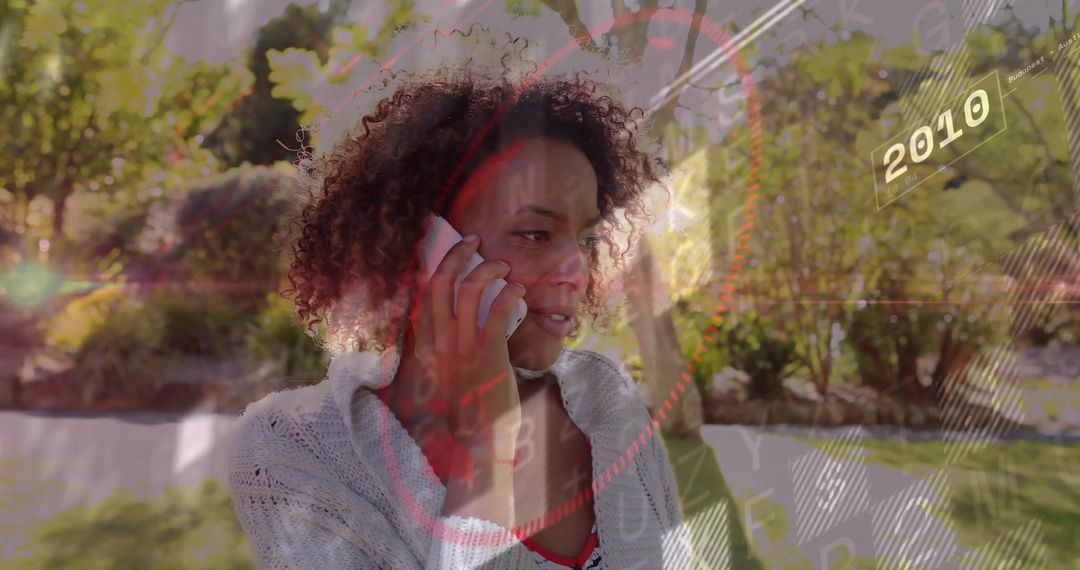 Woman Talking on Smartphone in Sunlit Garden with Futuristic HUD 2010 Overlay
