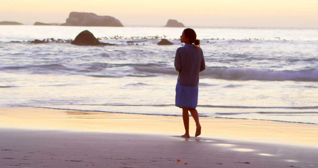 Woman Reflecting While Strolling on Tranquil Beach at Sunset - Free Images, Stock Photos and Pictures on Pikwizard.com