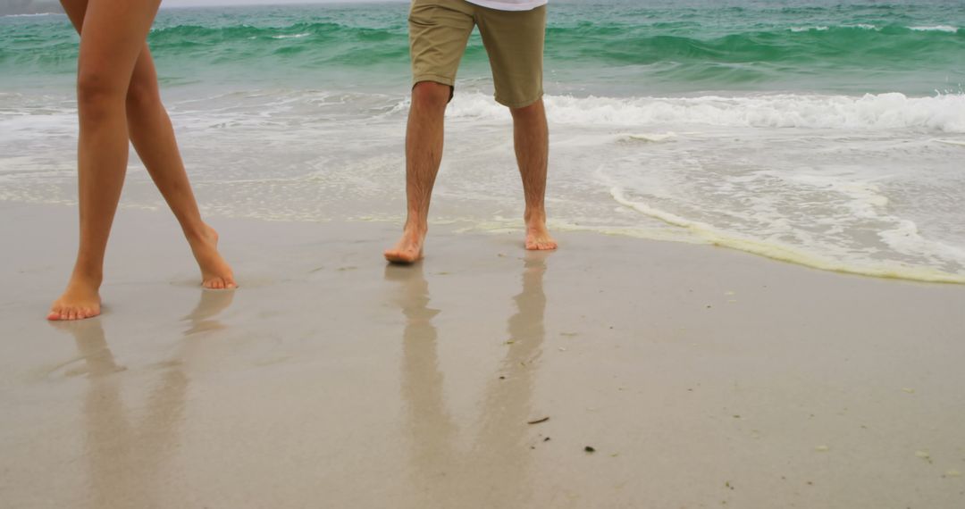 Couple Strolling on Beach, Enjoying Ocean Waves