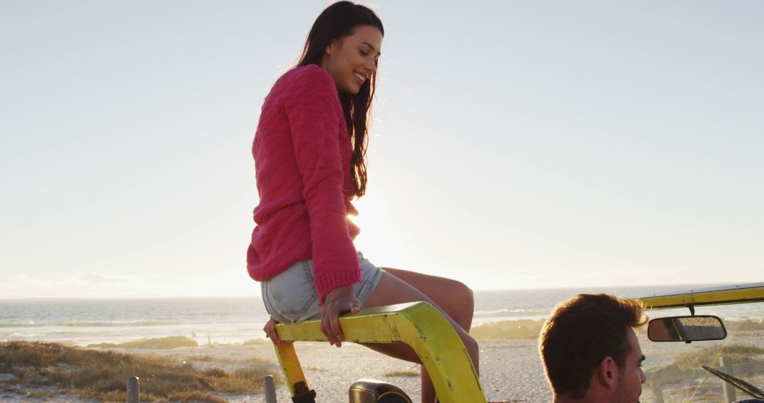 Young Woman Sitting on Car Roof at Beach During Sunset - Free Images, Stock Photos and Pictures on Pikwizard.com