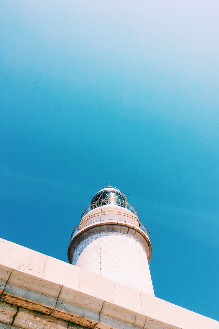 Lighthouse under Clear Blue Sky with Minimalistic Style - Free Images, Stock Photos and Pictures on Pikwizard.com