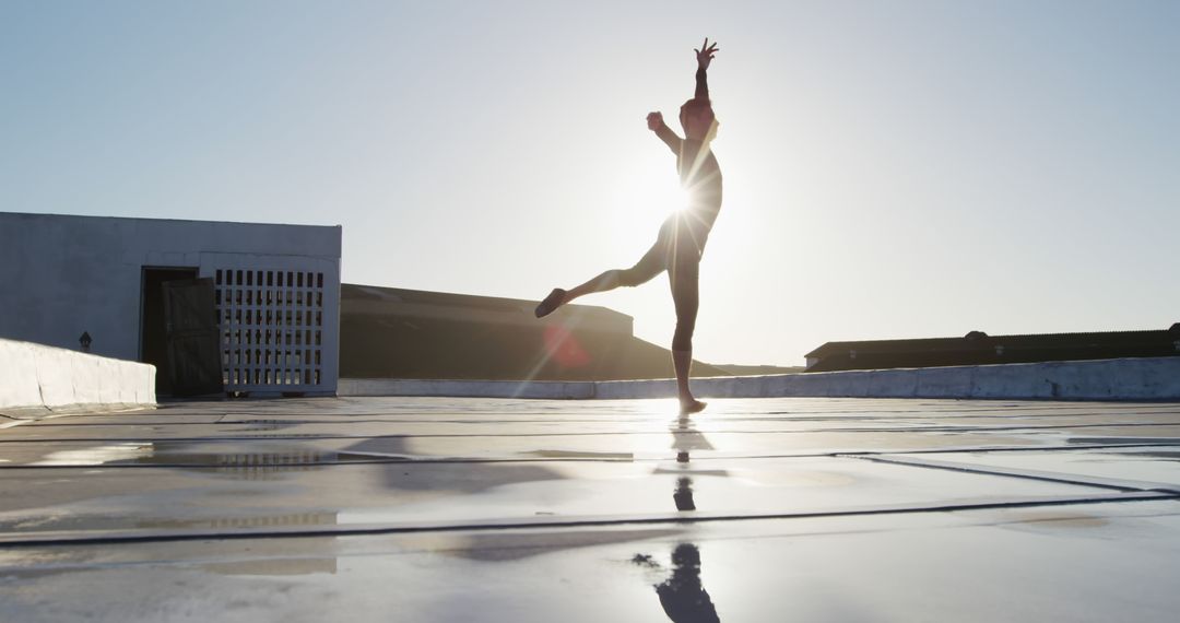 Ballet Dancer Performing on Rooftop at Sunrise with Lens Flare - Free Images, Stock Photos and Pictures on Pikwizard.com