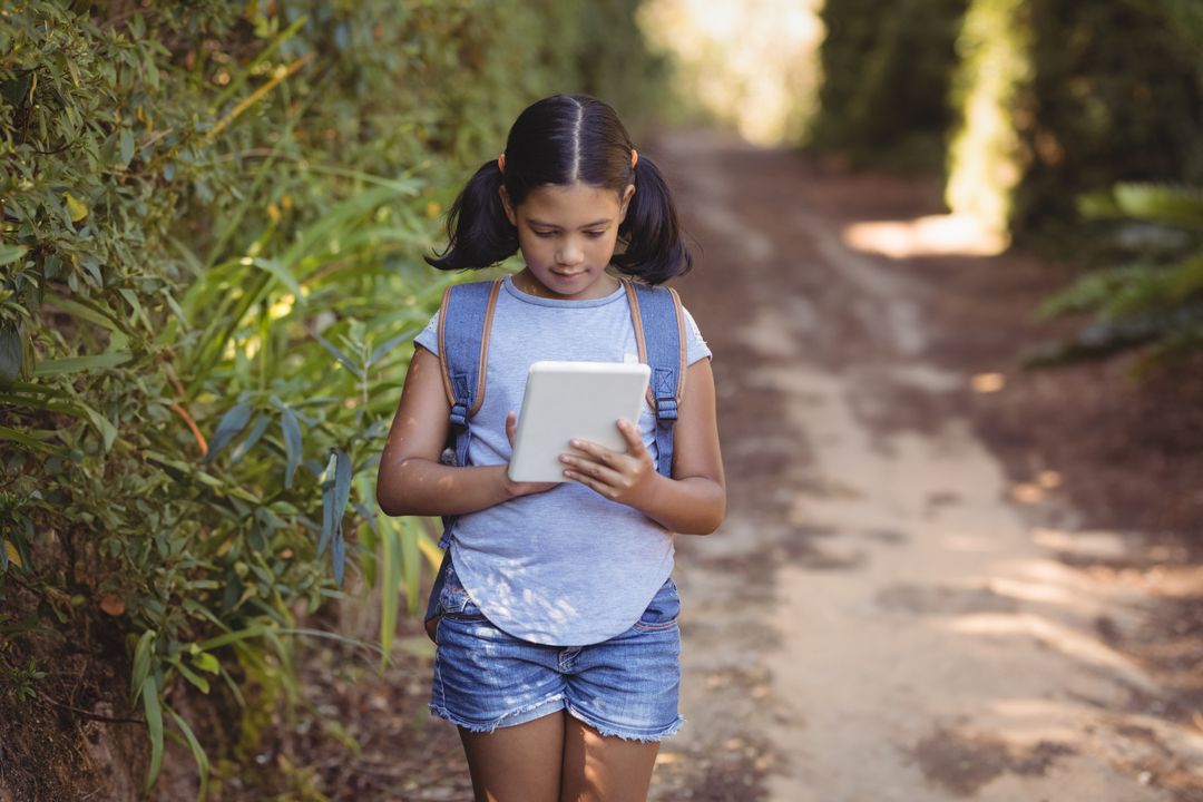 Child Exploring Nature While Using Tablet on Forest Trail