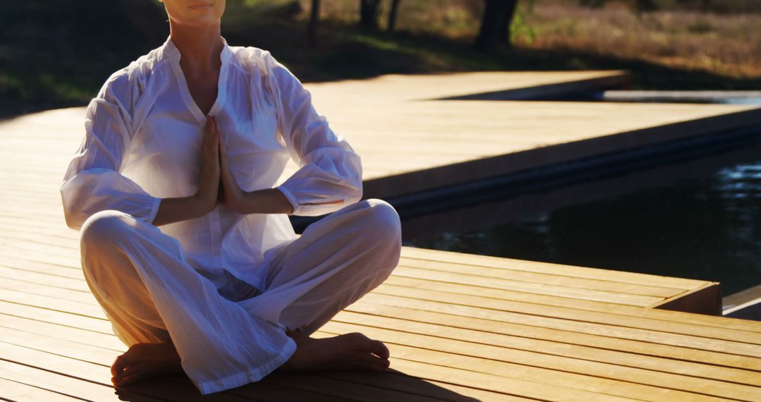 Woman Meditating by Pool at Sunrise on Wooden Deck - Free Images, Stock Photos and Pictures on Pikwizard.com