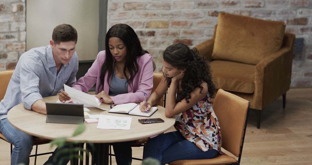 Diverse Team Collaborating on Office Project with Tablet