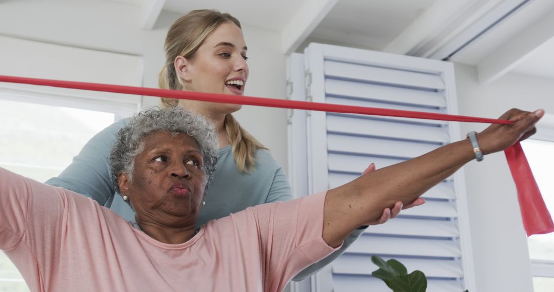 Elderly Woman Using Resistance Band with Assistance - Free Images, Stock Photos and Pictures on Pikwizard.com