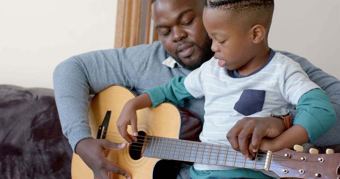 African American Father and Son Bond Playing Guitar at Home - Free Images, Stock Photos and Pictures on Pikwizard.com