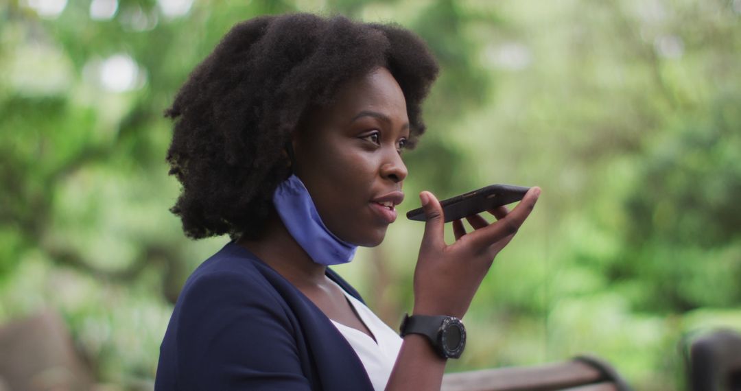 African American woman using voice assistant on smartphone in outdoor park - Free Images, Stock Photos and Pictures on Pikwizard.com