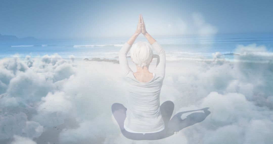 Serene Elderly Woman Meditating Above Clouds on Beach - Free Images, Stock Photos and Pictures on Pikwizard.com