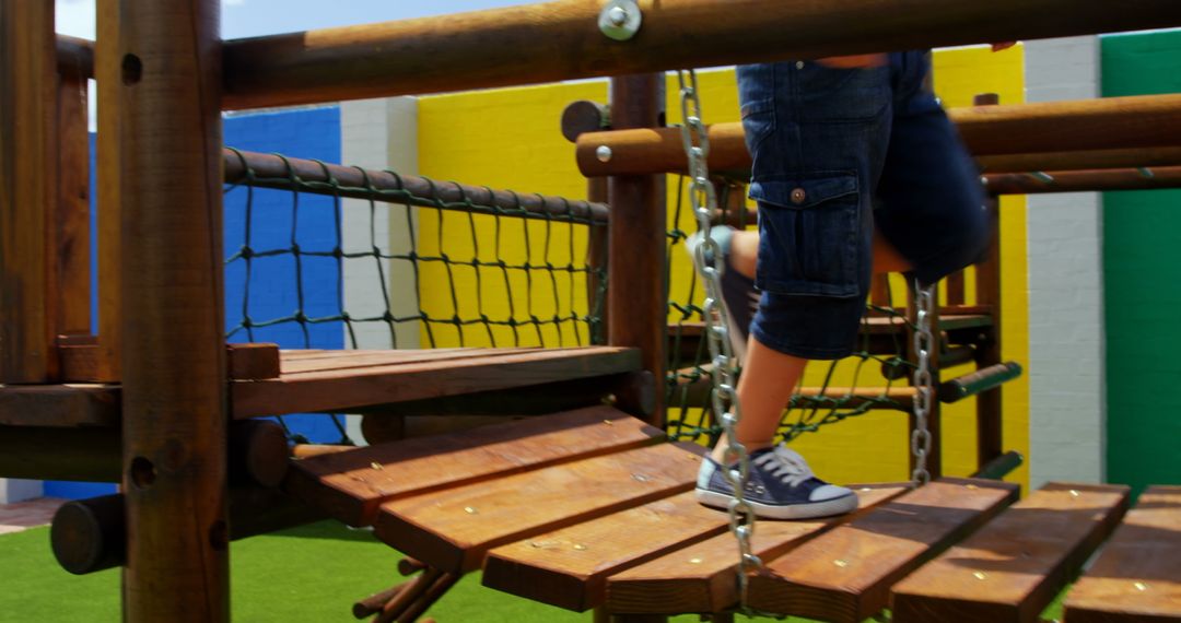 Child Playing on Wooden Playground Structure with Chains