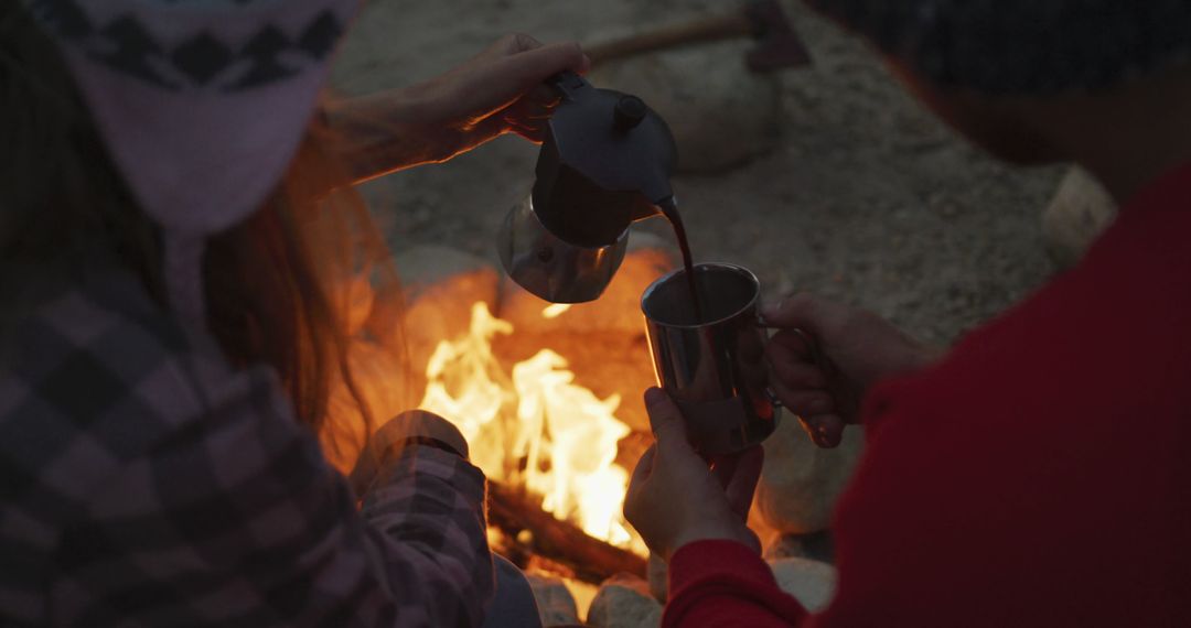 Couple Enjoying Coffee by Campfire in Mountain Setting