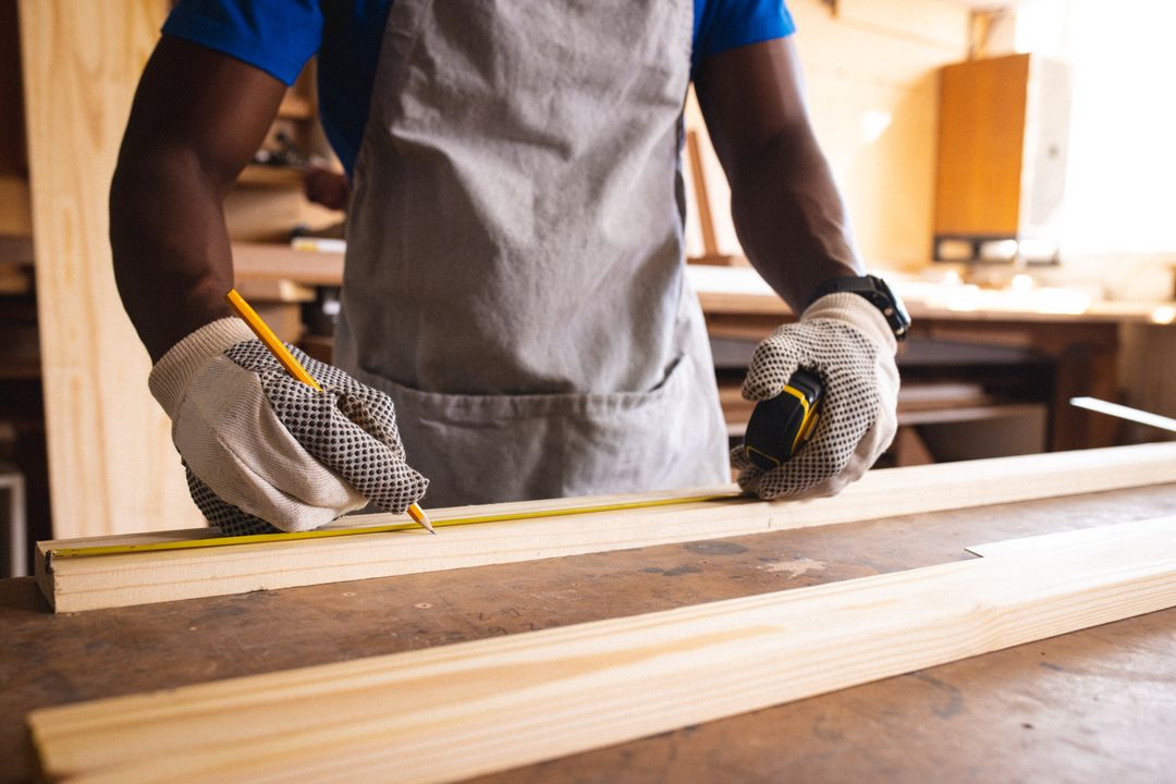 Skilled Carpenter Measuring Wooden Plank in Workshop - Free Images, Stock Photos and Pictures on Pikwizard.com