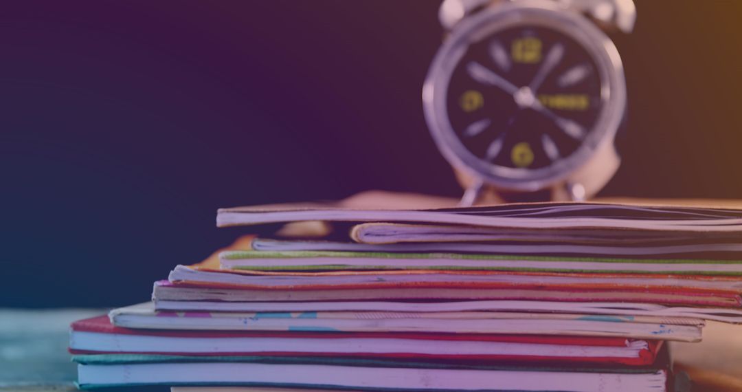 Stack of Books and Retro Clock on Unfocused Black Background - Free Images, Stock Photos and Pictures on Pikwizard.com