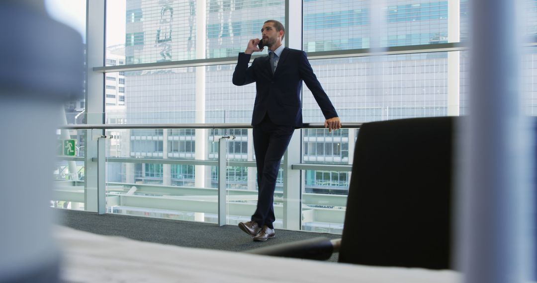 Successful Businessman Talking on Phone in Modern Office - Free Images, Stock Photos and Pictures on Pikwizard.com