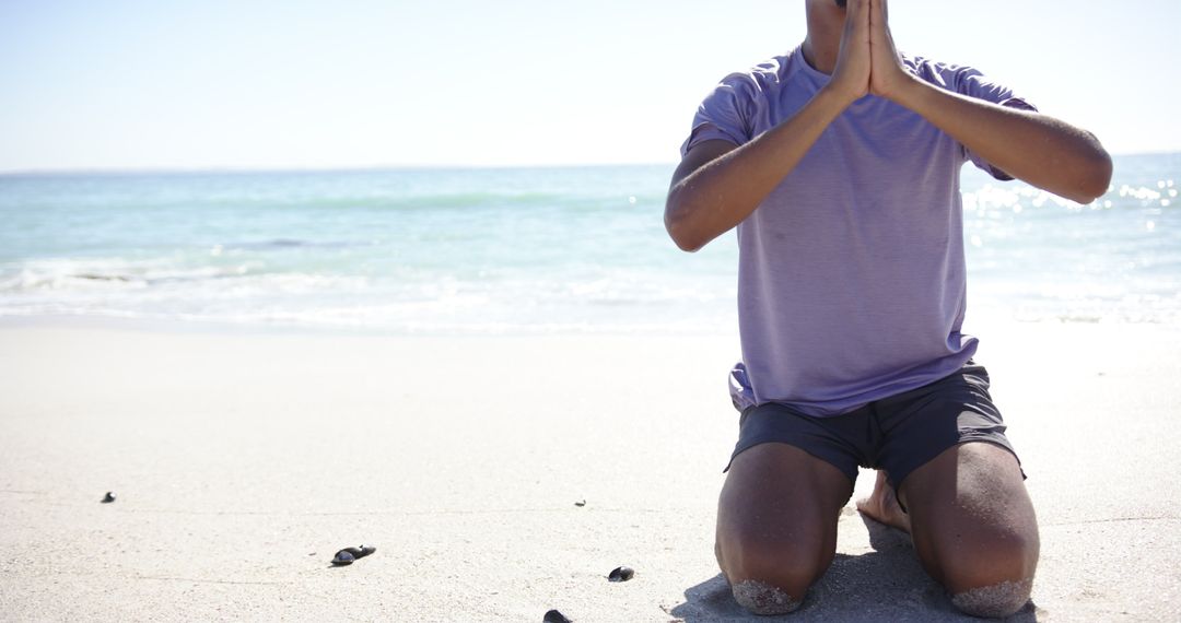 Young Man Meditating on Sunny Beachfront