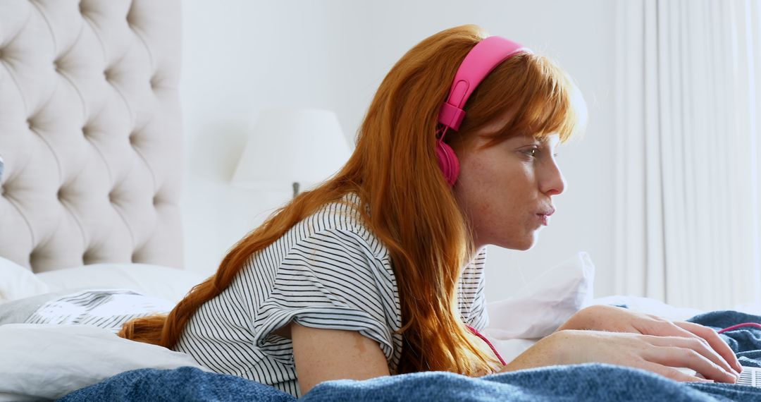 Beautiful woman listening music while using laptop in bedroom 4k - Free Images, Stock Photos and Pictures on Pikwizard.com