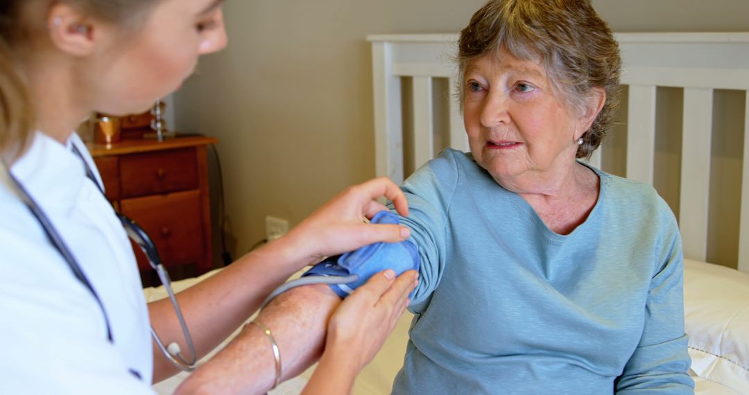 Nurse Assisting Elderly Woman with Blood Pressure Measurement in Home Setting - Free Images, Stock Photos and Pictures on Pikwizard.com