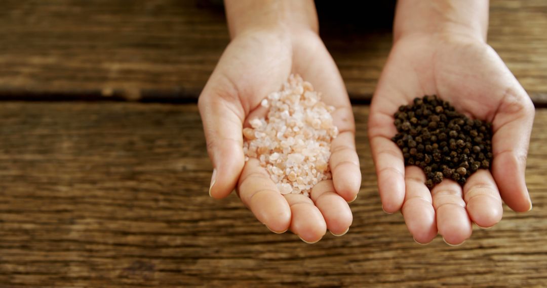 Hands Holding Pink Himalayan Salt and Black Peppercorns - Free Images, Stock Photos and Pictures on Pikwizard.com